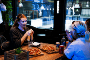 Friends sitting down, enjoying pizza at Formula Fast Karting Milton Keynes